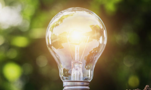 concept saving energy lightbulb with solar power in nature